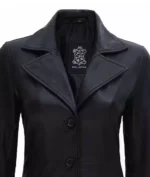 Black leather jacket with wide lapels and two front buttons. The label inside reads "Real Leather." The style is sleek and minimalist.