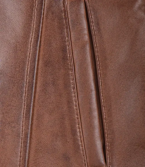 Close-up of a brown leather texture with visible stitching and folds. The leather has a smooth yet slightly textured appearance, conveying a sense of warmth and durability.